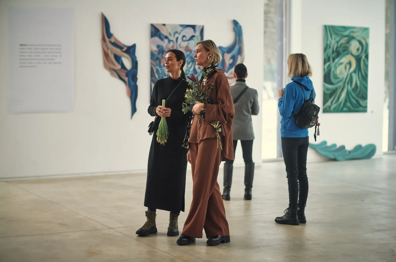 Visitors among paintings at Dimension of the Heart
