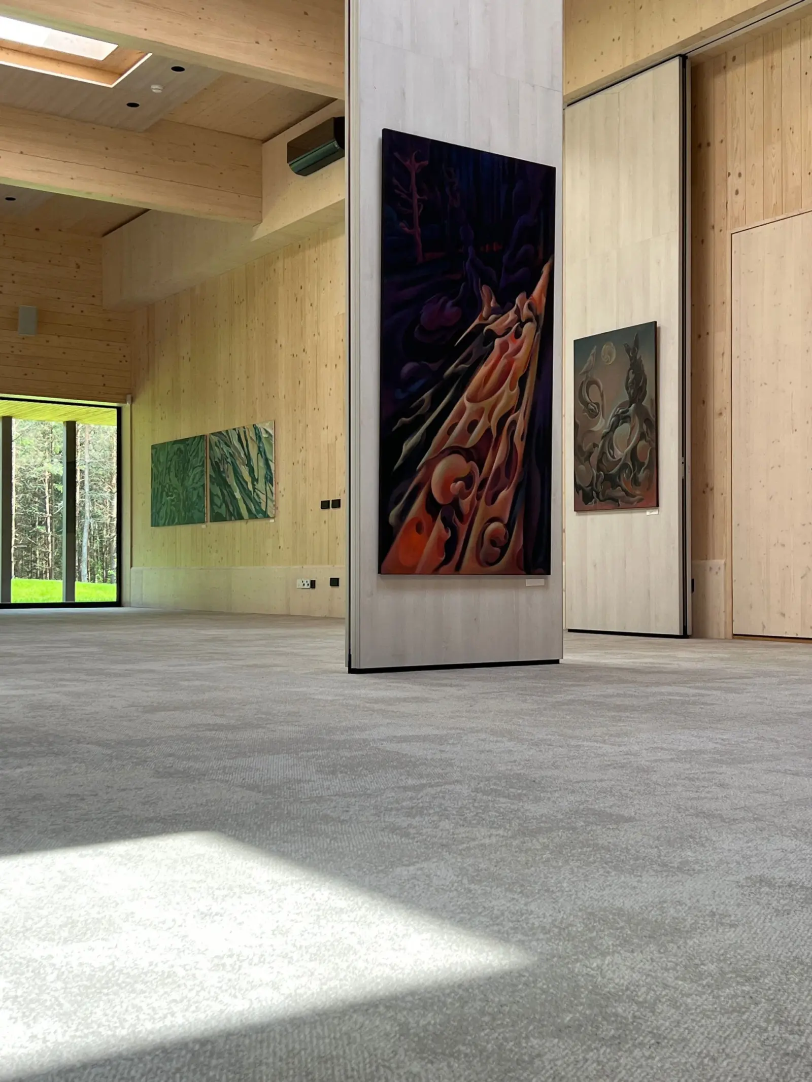 A painting on a timber column in the sunlit Nuoramos exhibition