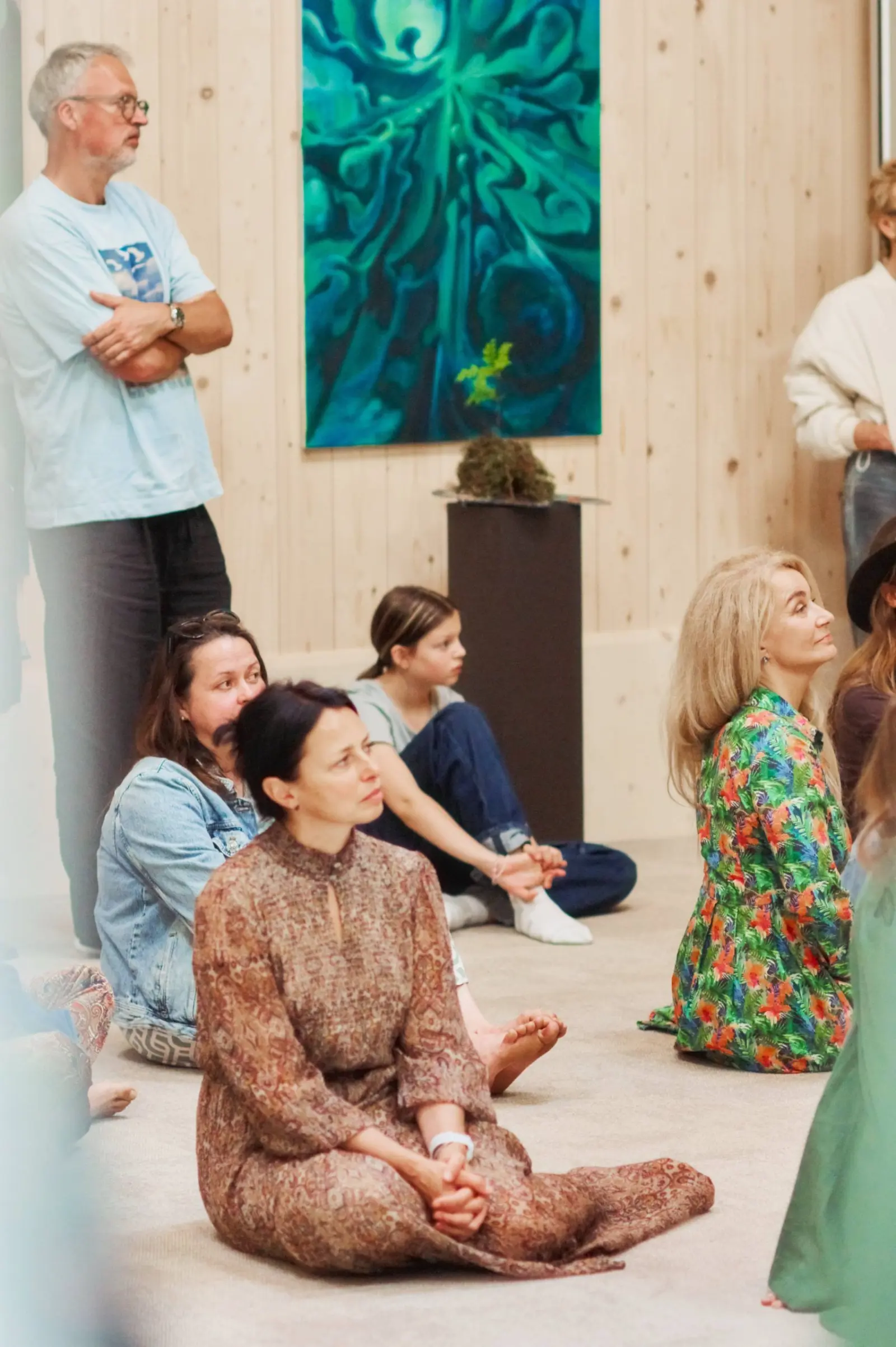 Seated and standing visitors listening at Nuoramos