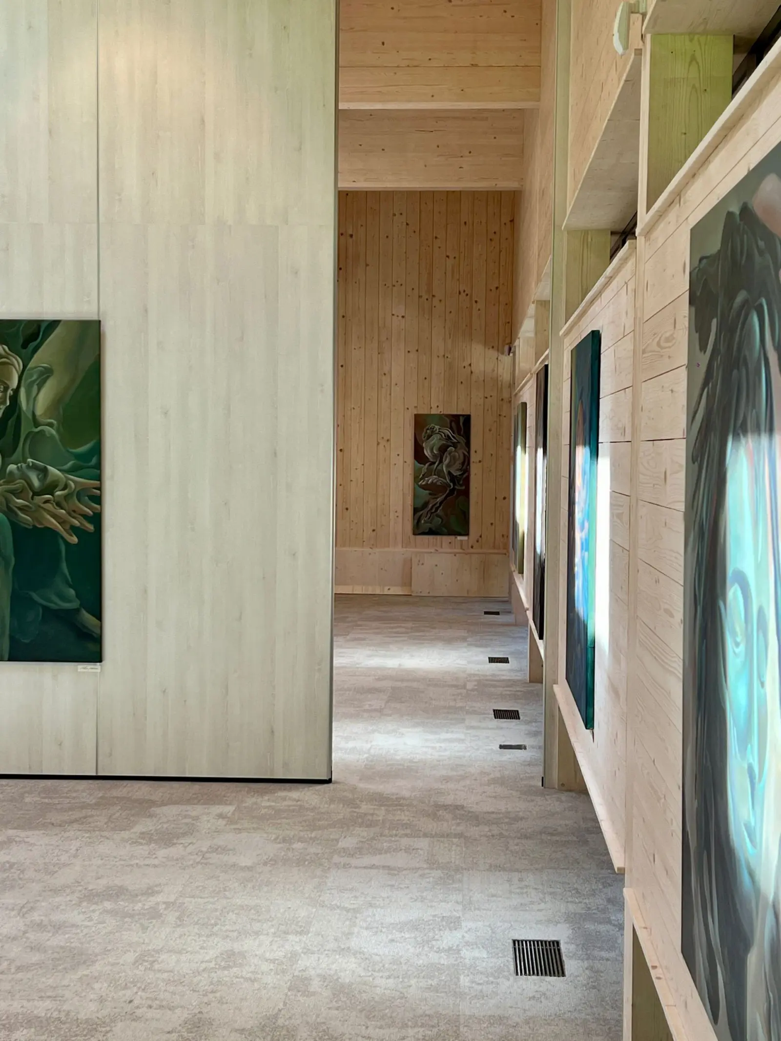 Paintings lining a timber corridor at Nuoramos