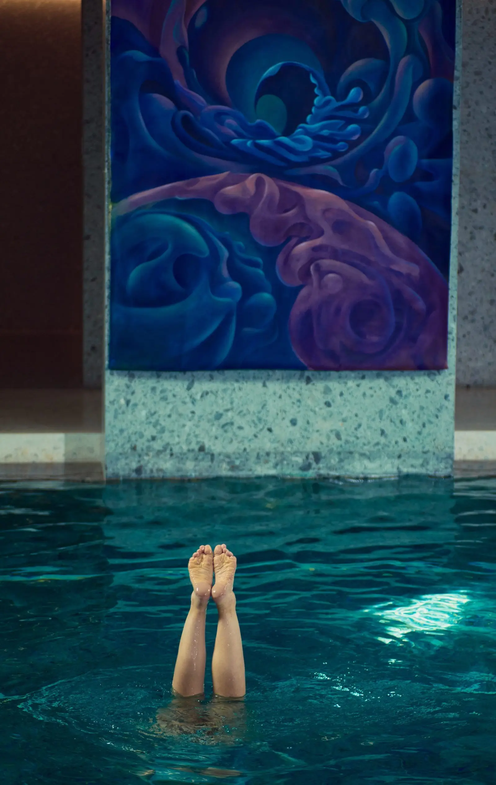 An aquatic performer beneath a purple painting at Water Body